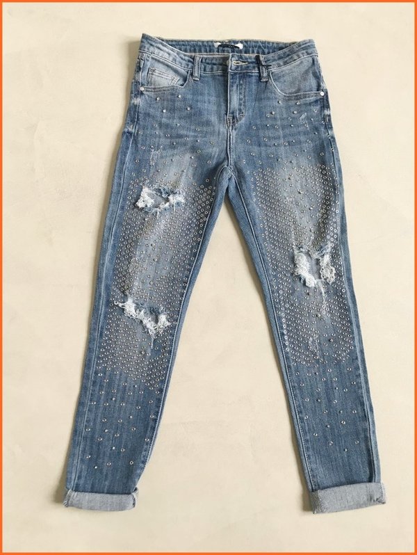 Jeans skinny rotture e borchiette dorate.