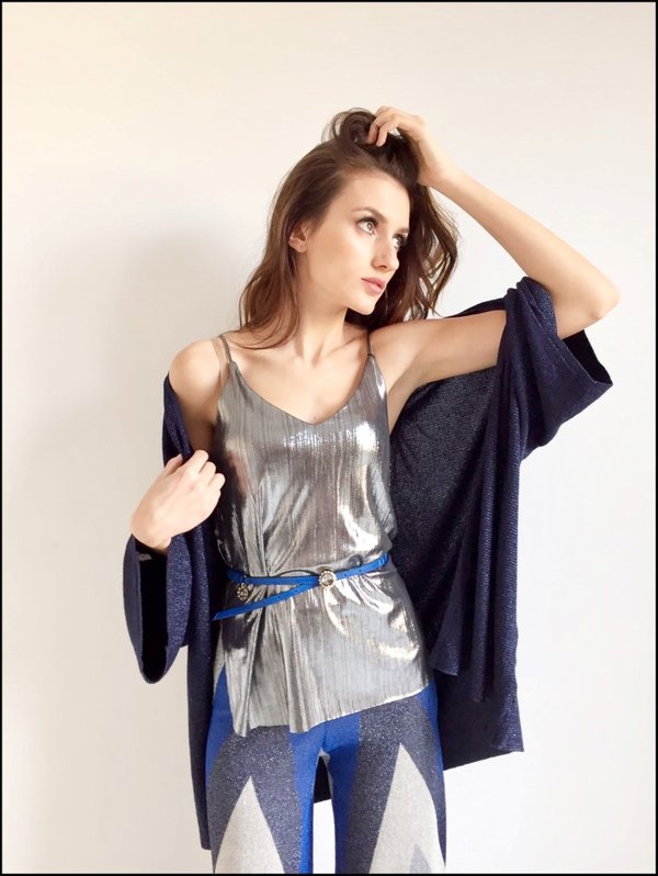 Top argentato con cardigan lurex blu e pantalone fantasia geometrica. Cinturina blu fibbia gioiello.