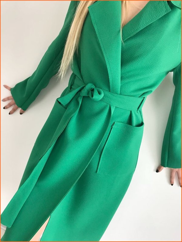 Trench con tasche e cintura verde.