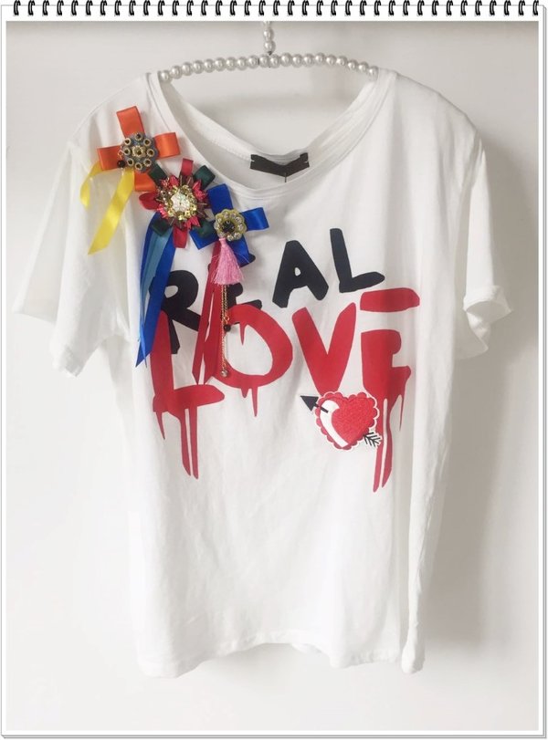 T-shirt real love con coccarde colorate.