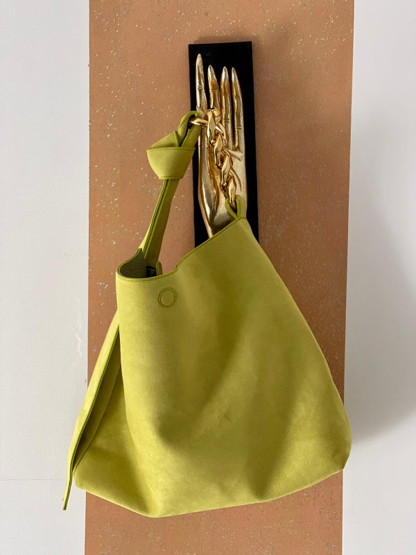 Borsa traforata lime con catene dorate.