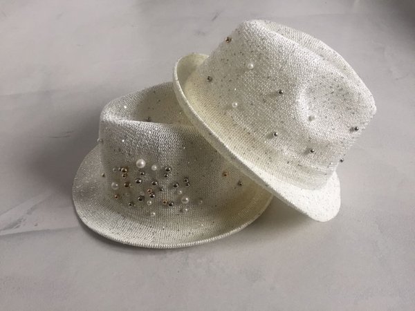 Cappello in rete con lurex perle e borchie applicate.