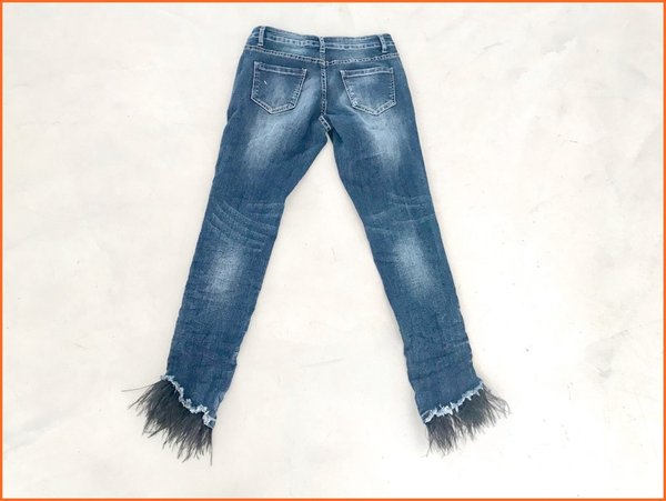 Jeans delavè con piume nere.