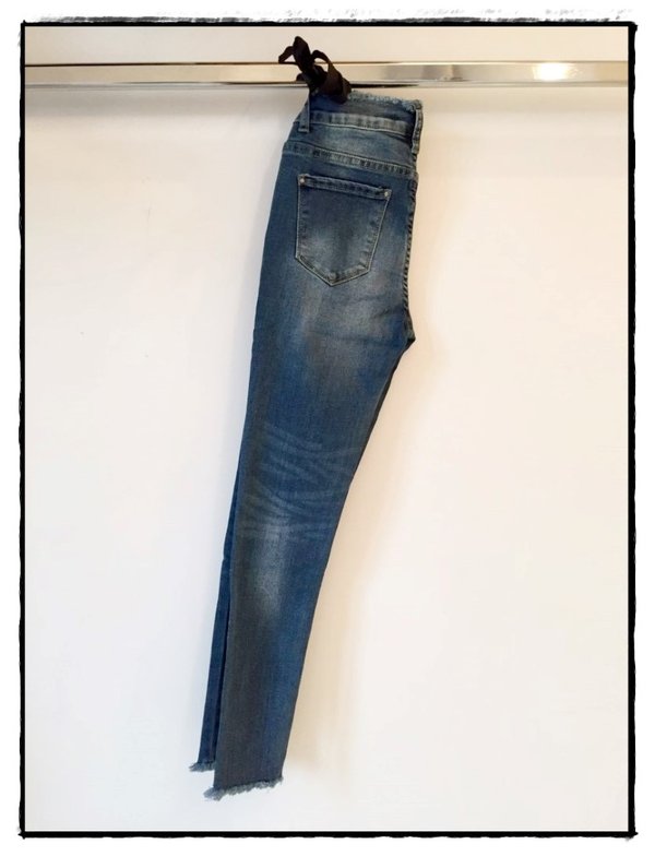 Jeans bielastico skinny sfrangiato in vita e alla caviglia.