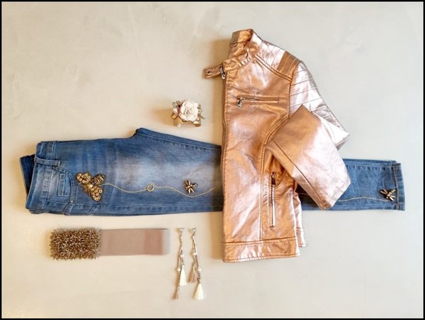 Jeans con applicazioni ape, giubbetto ecopelle dorato, bracciale rigido con fiori , cintura elasticizzata con corallini e orecchini lunghi nappine.