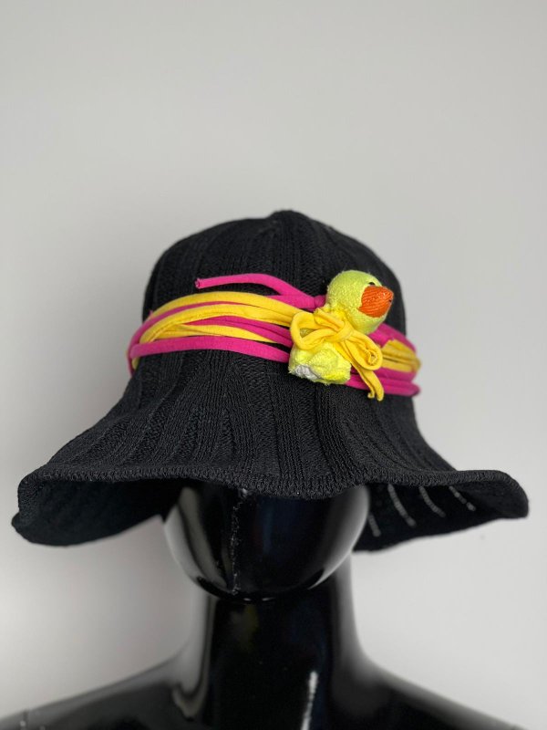 Cappello in maglia nero con pulcino e dettagli colorati.