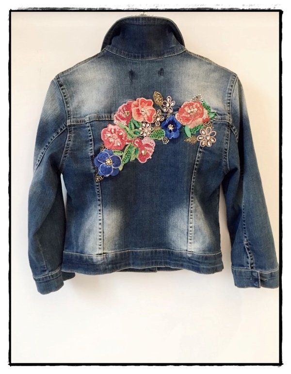 Giubbetto jeans bielastico con applicazioni di fiori colorati sulla schiena e davanti.
