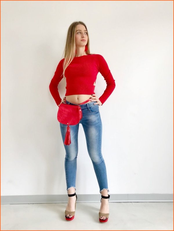 Crop top rosso con jeans sfrangiato e marsupio luminoso nappina frange.