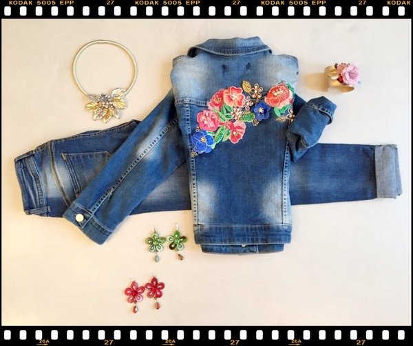 Giubbetto jeans con fiori, jeans risvolto, collana e bracciale fiori applicati e orecchini fiore.