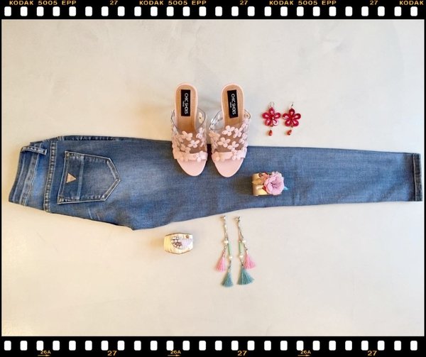 Jeans risvolto, sabot fiori rosa, bracciali rigidi, orecchini lunghi nappine e orecchini fiore rossi.