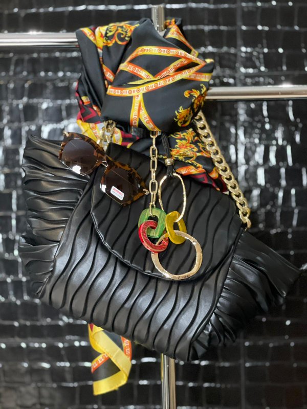 Borsa matelassè nera con tracolla catene, collana anelli colorati, sunglasses tendenza e foulard fantasia 