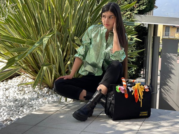 Camicia verde menta con pantalone nero e borsa.