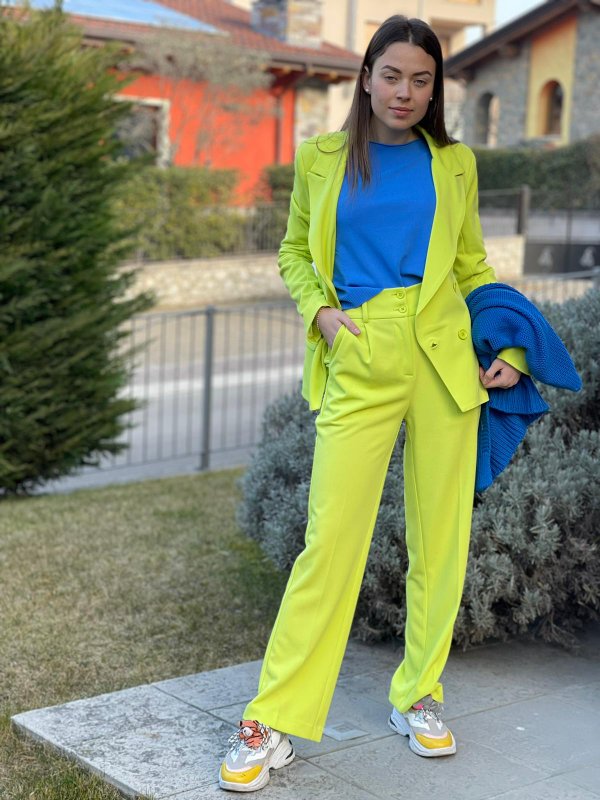 Giacca e pantalone lime, maglia e cardigan bluette a contrasto.