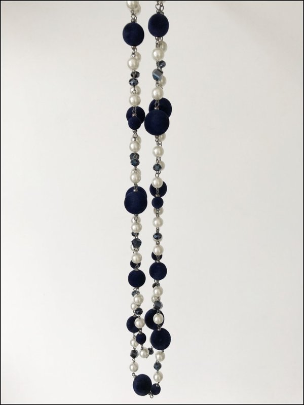 Collana lunga con perle bianche e blu in velluto.