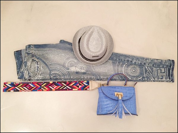 Jeans interamente tempestati di swarovski, borsa azzurra con nappina e tracolla colorata, cappello lurex argento.